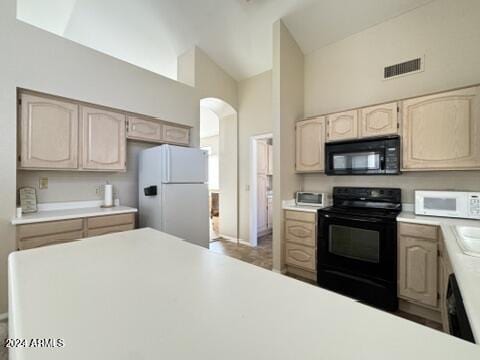 kitchen featuring light brown cabinets, high vaulted ceiling, black appliances, and sink