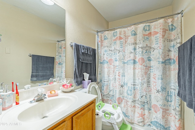 bathroom with toilet, vanity, and a shower with shower curtain