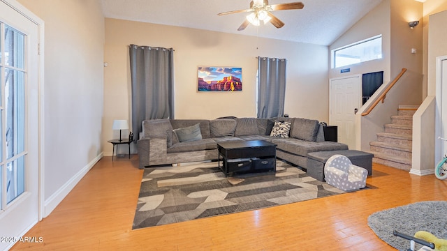 living room featuring ceiling fan, wood-type flooring, and lofted ceiling