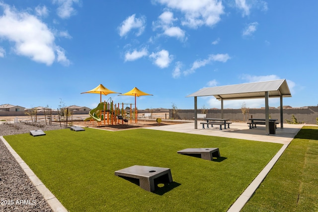 view of property's community with playground community, fence, and a lawn