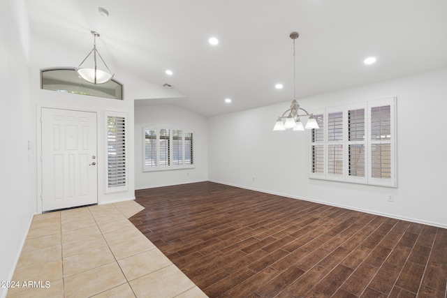 foyer entrance with a chandelier and vaulted ceiling