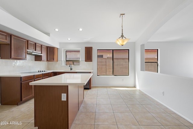 kitchen with decorative backsplash, sink, light tile patterned floors, a kitchen island, and hanging light fixtures