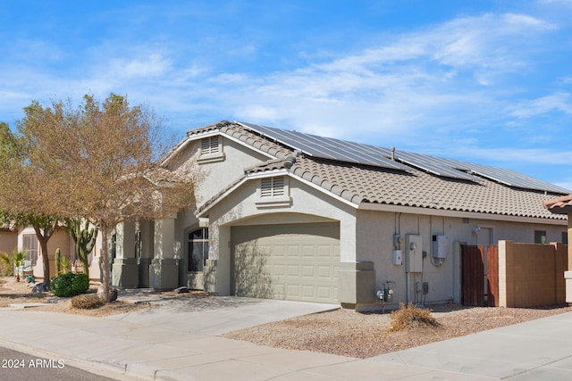 view of front of house featuring solar panels and a garage