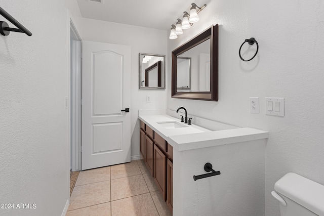 bathroom with tile patterned flooring, vanity, and toilet