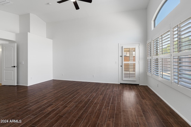 spare room with a high ceiling, dark hardwood / wood-style flooring, and ceiling fan