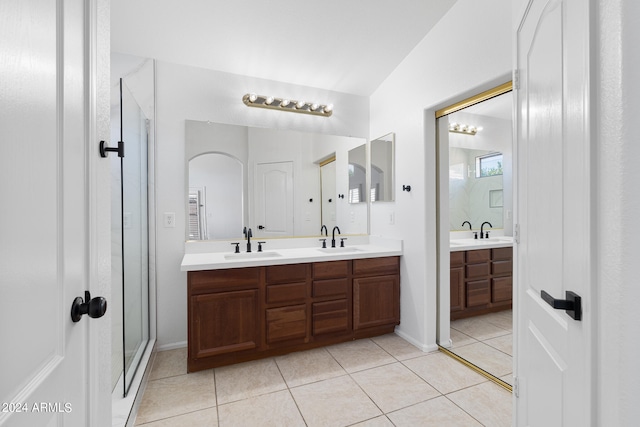 bathroom featuring tile patterned floors, vanity, and a shower with shower door