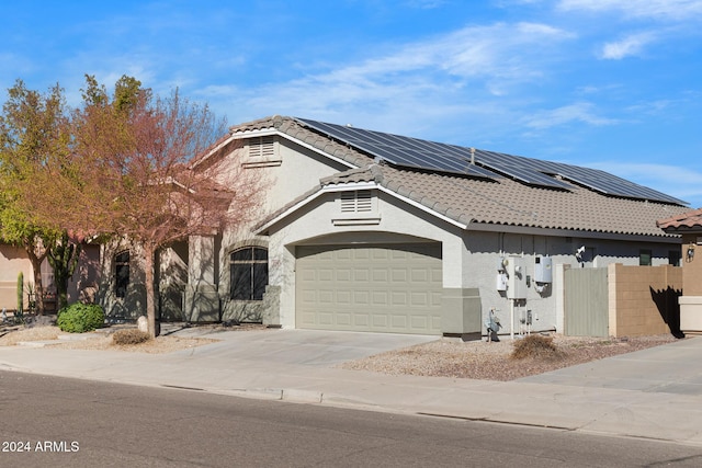 view of front facade featuring solar panels and a garage