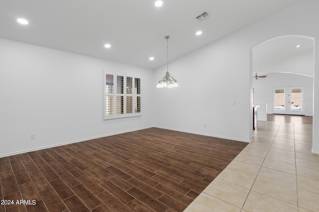 spare room with ceiling fan with notable chandelier