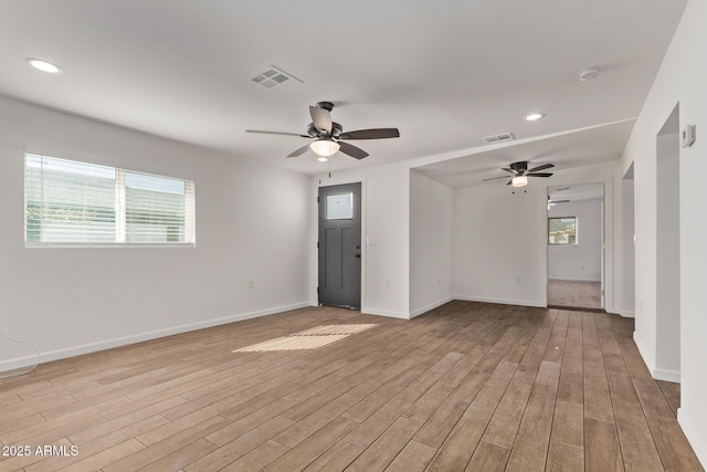 spare room with light wood finished floors, baseboards, and visible vents