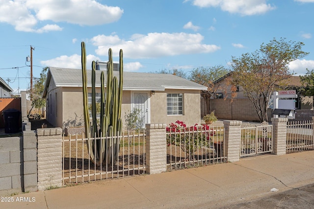 view of front of property with a fenced front yard, a gate, and stucco siding