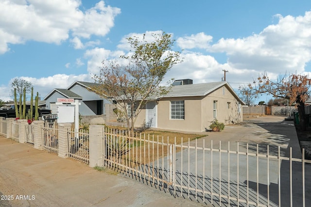 view of front of property with a fenced front yard, a gate, and stucco siding