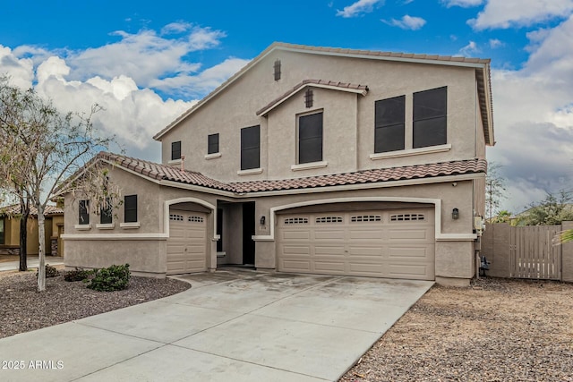 view of front of home with stucco siding, fence, driveway, and a tiled roof