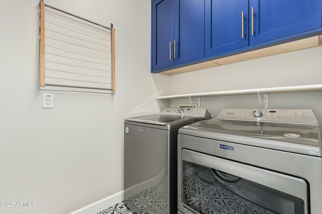 laundry area with baseboards, cabinet space, and washing machine and dryer