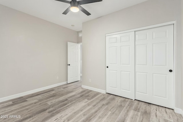 unfurnished bedroom with a closet, baseboards, wood finished floors, and a ceiling fan