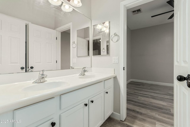 bathroom with a sink, visible vents, baseboards, and double vanity