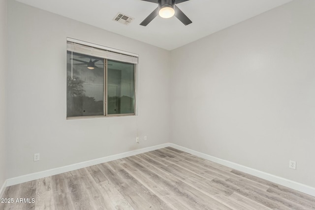 unfurnished room featuring baseboards, wood finished floors, visible vents, and ceiling fan