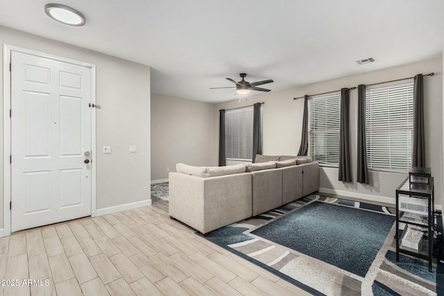 unfurnished living room with visible vents, baseboards, light wood-style floors, and ceiling fan