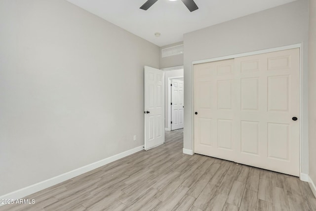 unfurnished bedroom with a closet, baseboards, light wood finished floors, and ceiling fan