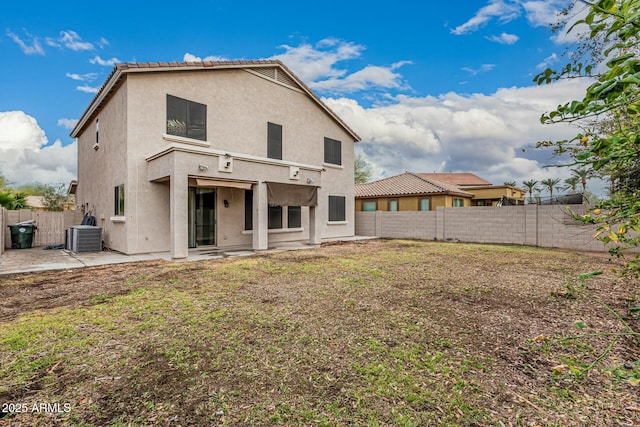 rear view of property featuring central AC unit, a fenced backyard, stucco siding, a tile roof, and a patio area