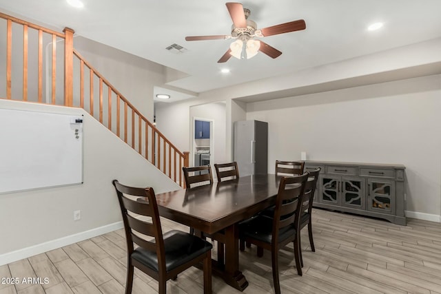 dining area featuring stairway, a ceiling fan, visible vents, and wood finish floors