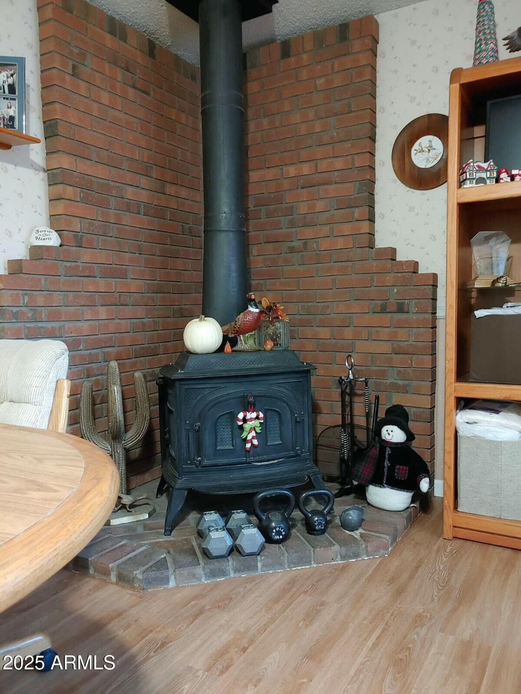 details with a wood stove and wood finished floors