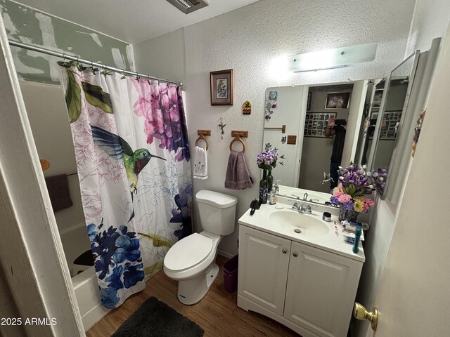 10833 N 43rd Dr, Glendale, AZ 85304 - bathroom featuring wood finished floors, vanity, toilet, shower / tub combo with curtain, and a textured wall