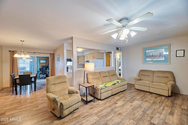 5410 E University Dr, Mesa, AZ 85205 - living room featuring light wood finished floors, a ceiling fan, and a chandelier