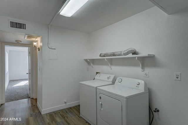 washroom with independent washer and dryer and light wood-type flooring