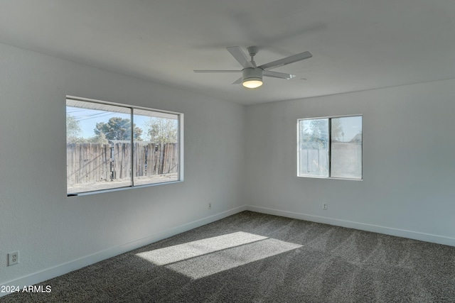 carpeted spare room featuring ceiling fan and a healthy amount of sunlight