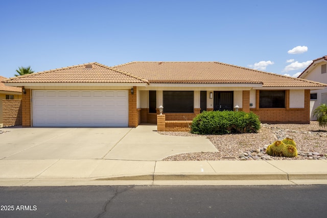 8230 E Navarro Ave, Mesa, AZ 85209 - view of front of house with brick siding, a tile roof, an attached garage, and concrete driveway