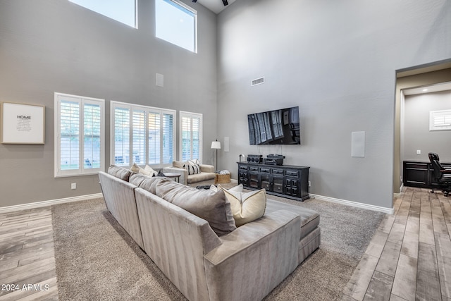 living room with a high ceiling and light wood-type flooring