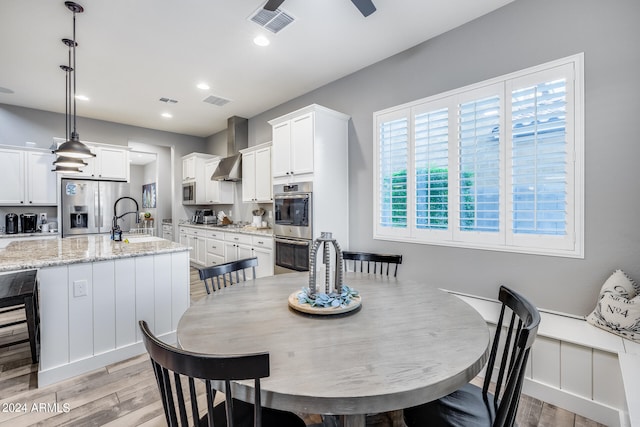 dining room with sink and light hardwood / wood-style flooring