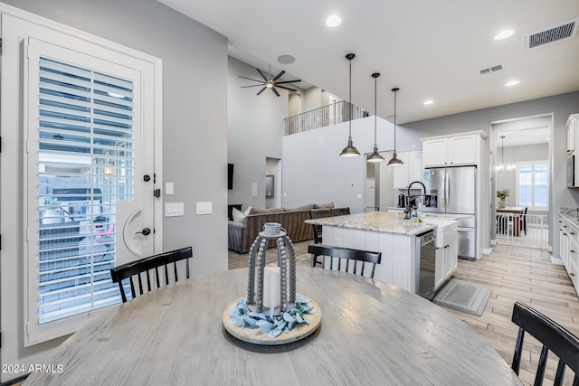 dining area featuring light hardwood / wood-style floors and ceiling fan with notable chandelier