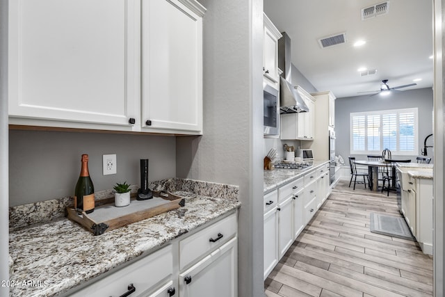 kitchen featuring light hardwood / wood-style floors, white cabinetry, and ceiling fan