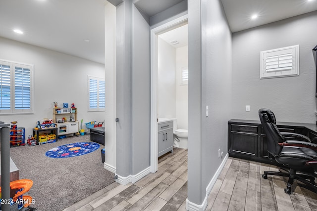 office with light hardwood / wood-style flooring and plenty of natural light