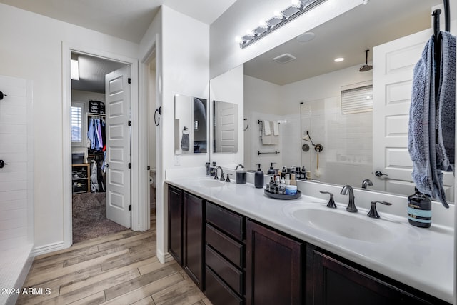 bathroom with vanity, wood-type flooring, and tiled shower