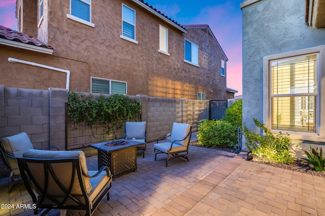 patio terrace at dusk featuring a fire pit