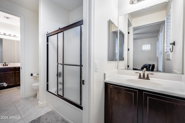 full bathroom featuring vanity, toilet, tile patterned floors, and bath / shower combo with glass door