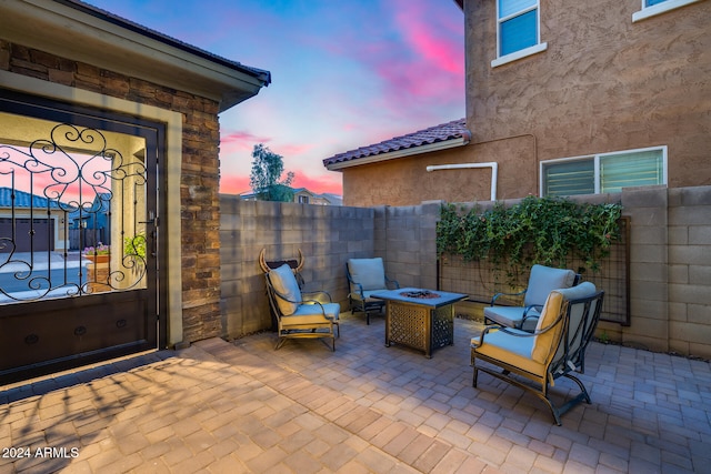 patio terrace at dusk featuring a fire pit