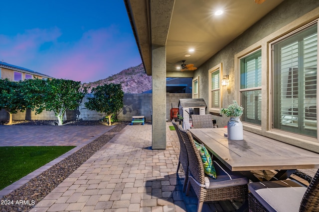 patio terrace at dusk featuring ceiling fan