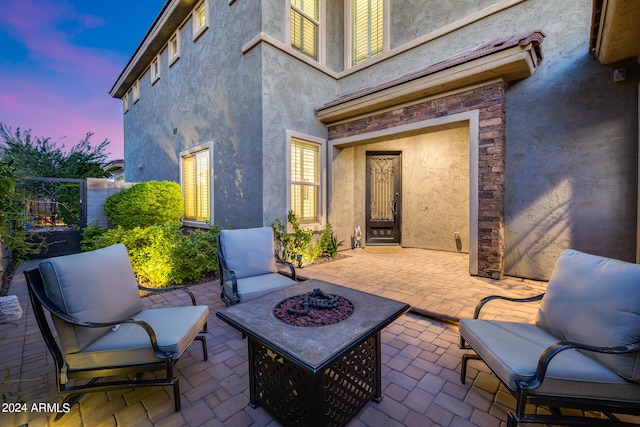 patio terrace at dusk featuring an outdoor fire pit