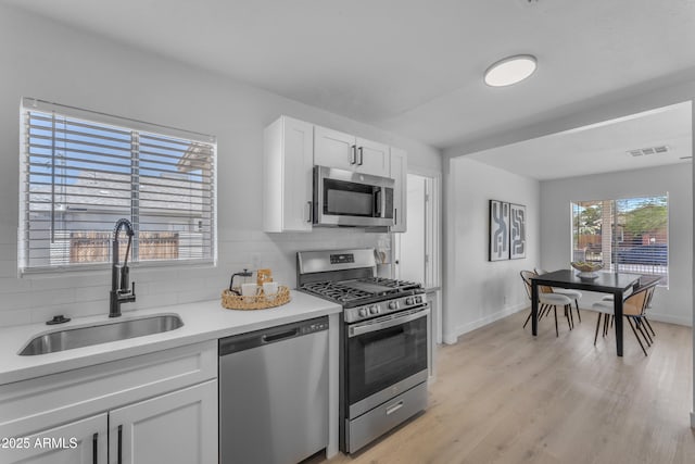 kitchen featuring visible vents, a sink, tasteful backsplash, and stainless steel appliances
