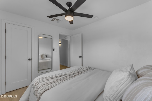 bedroom with light wood-type flooring, visible vents, and a ceiling fan