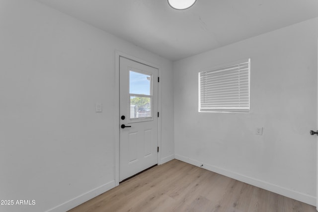 entryway with baseboards and light wood-style flooring