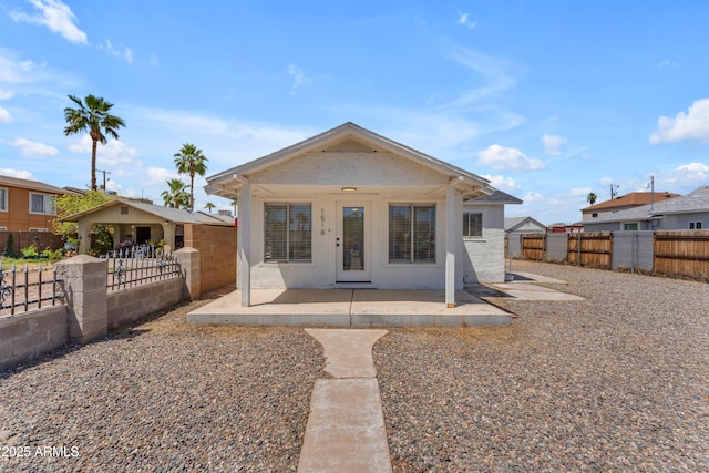 bungalow-style house featuring covered porch and fence private yard
