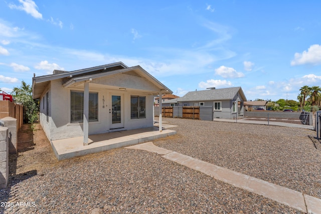 back of property with a patio area, stucco siding, and a fenced backyard
