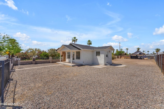 back of house with a fenced backyard and a patio area