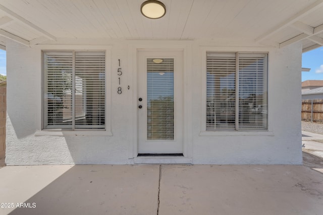 entrance to property with a patio and stucco siding