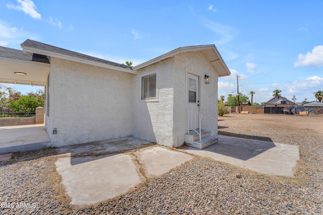 exterior space featuring stucco siding, fence, and a patio