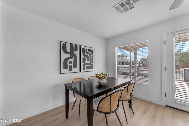 dining area featuring baseboards, a ceiling fan, light wood finished floors, and visible vents